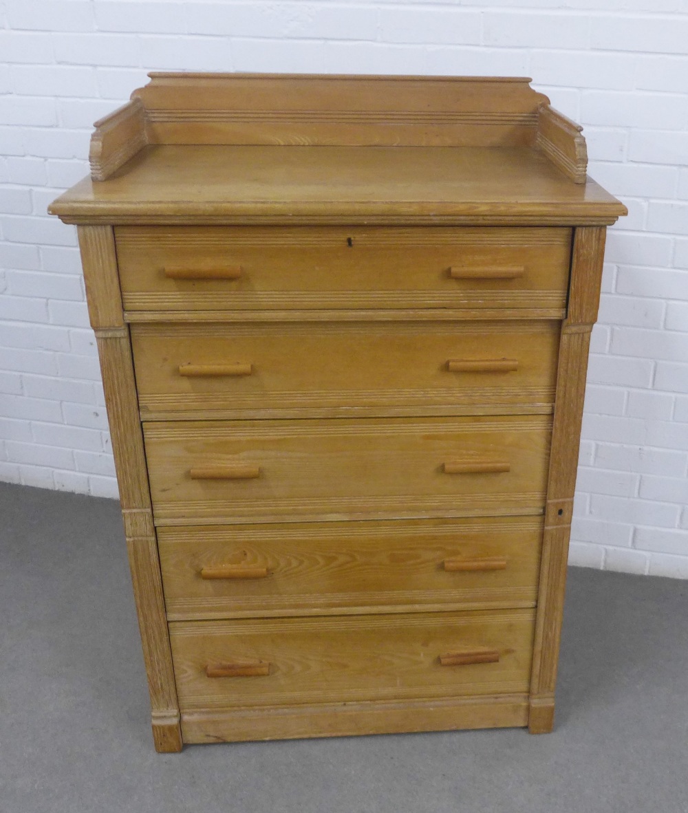 Pine chest of drawers with a ledgeback and five long drawers flanked by a Wellington style lock,