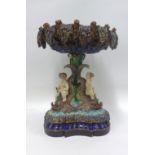 Continental majolica table centre piece, the scalloped bowl raised on base with cherubs and
