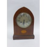 Mahogany cased mantle clock, the arched top over a silvered dial with Arabic numerals, raised on