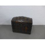 An antique oak and iron bound trunk with a domed top, the strap work with engraved shell pattern,