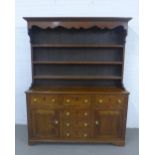 An oak Welsh style dresser with a moulded cornice and shelved back over an arrangement of six