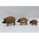 Three wood and metal mounted pigs of graduating size, largest 30cm long (3)