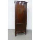 Mahogany floor standing cupboard with a single paneled bowfront door, void hanging space and