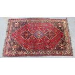 Shiraz rug, madder ground with a triple pole medallion and stylised ivory border, 264 x 167cm