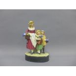 Royal Doulton figure of a flower seller with two children, on a black oval base, impressed 454 and
