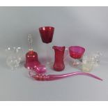 A collection of cranberry glass to include a bell, pipe and large goblet, etc, together with an