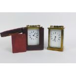 Two brass and glass panelled carriage clocks, one with a leather outer case, (2)