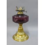 Early 20th century brass oil lamp with amethyst glass well, 22cm