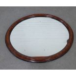 A faux walnut and ebony framed mirror with an oval plate, 90 x 70cm