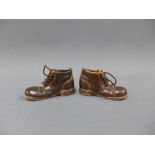 A pair of brown glazed pottery boots with leather laces, 7.5cm long