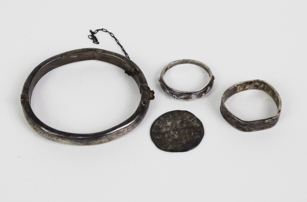 An early coin, silver baby's bangle and two silver rings, (4)