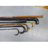 A collection of six late 19th and early 20th century walking canes to include silver mounted,