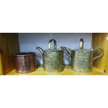 Two early 20th century brass watering cans and a large copper cup, (3)