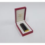 Cartier gold plated and black enamel cigarette lighter, in red leather presentation box
