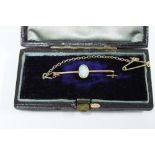 Unmarked gold opal bar brooch with a safety chain and fitted box