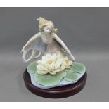 Lladro figure of a fairy on a lily pad, including wooden base, two loose petals, 25cm wide