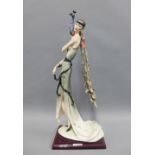 Florence resin figure of a flapper girl with a peacock, on a wooden base,