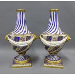 A pair of Sevres style floral painted and gilt vases, with lion mask heads and garland swags, on