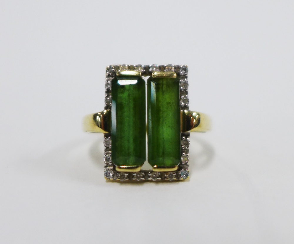 9ct gold dress ring with two emerald cut green stone within a surround of claw set diamonds