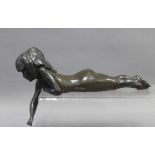 Bronze patinated resin figure of a reclining girl, signed, (repair to her arm) 26cm
