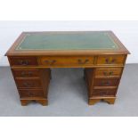 Reproduction pedestal desk with green skivver over an arrangement of nine drawers, 122 x 79 x 60cm
