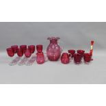 Collection of cranberry glass to include a water jug, various drinking glasses, two small jugs and a