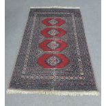 Pakistan rug, worn red field with four central medallions within multiple geometric borders, 142 x