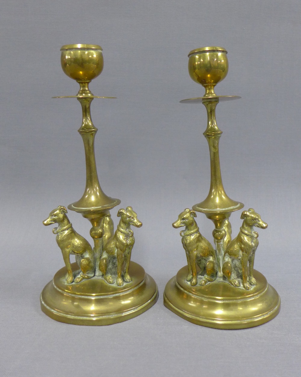 Pair of brass knop stemmed candlesticks, the circular bases with three hounds, 19cm (2)