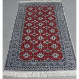 Pakistan rug, red field with allover foliate pattern, within geometric borders, 182 x 122cm