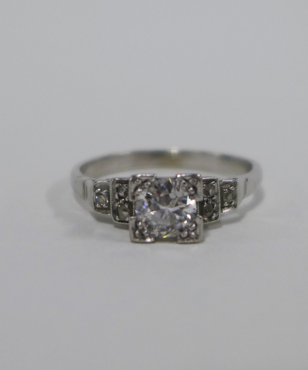 Diamond ring, with a claw set bright cut diamond with three further diamonds to the stepped