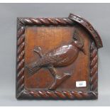 Carved mahogany panel depicting a bird within a rope twist border, 32 x 33cm