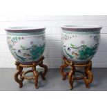 Two large Chinese fish bowls, with magpies and ducks pattern, on stylised wooden stands, 38 x 30cm