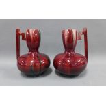 Pair of Christopher Dresser style red glazed jugs, with angular side handle, 20cm (2)