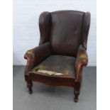 Late 19th / early 20th century faux brown leather upholstered wing back armchair with carved arm