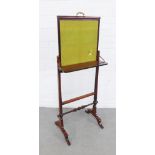 Mahogany screen with a rising fabric panel on twin shaped side supports, with a folding shelf, 50