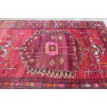 Persian carpet / rug, red field with geometric motifs, hooked and flowerhead borders, 226 x 350cm (