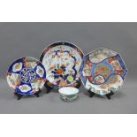 Two Imari chargers another smaller and an Imari octagonal plate and a Famille Verte bowl, largest
