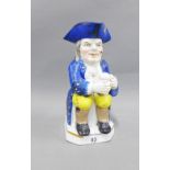 19th century Toby Jug, typically modelled seated with a jug of ale, wearing blue frock coat and