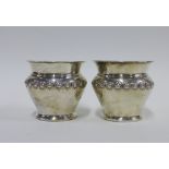 A pair of silver bowls / pots with embossed floral pattern, London 1909, 7cm (2)