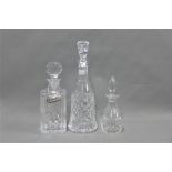 Three various cut glass decanters with stoppers , one with a whisky decanter label (4)