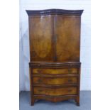 Mahogany and walnut oyster veneered serpentine cabinet , with dentil frieze over a pair of