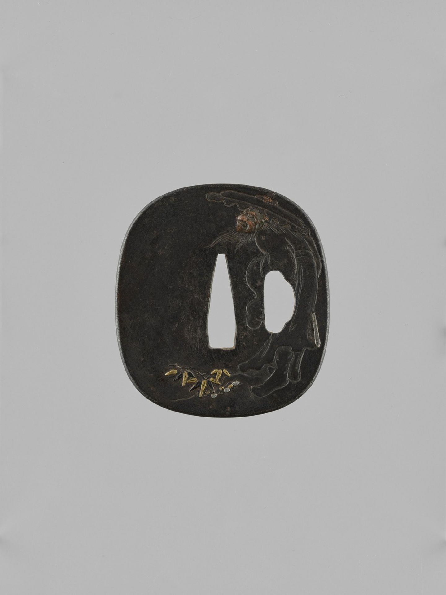 AN IRON TSUBA DEPICTING SHOKI AND ONI