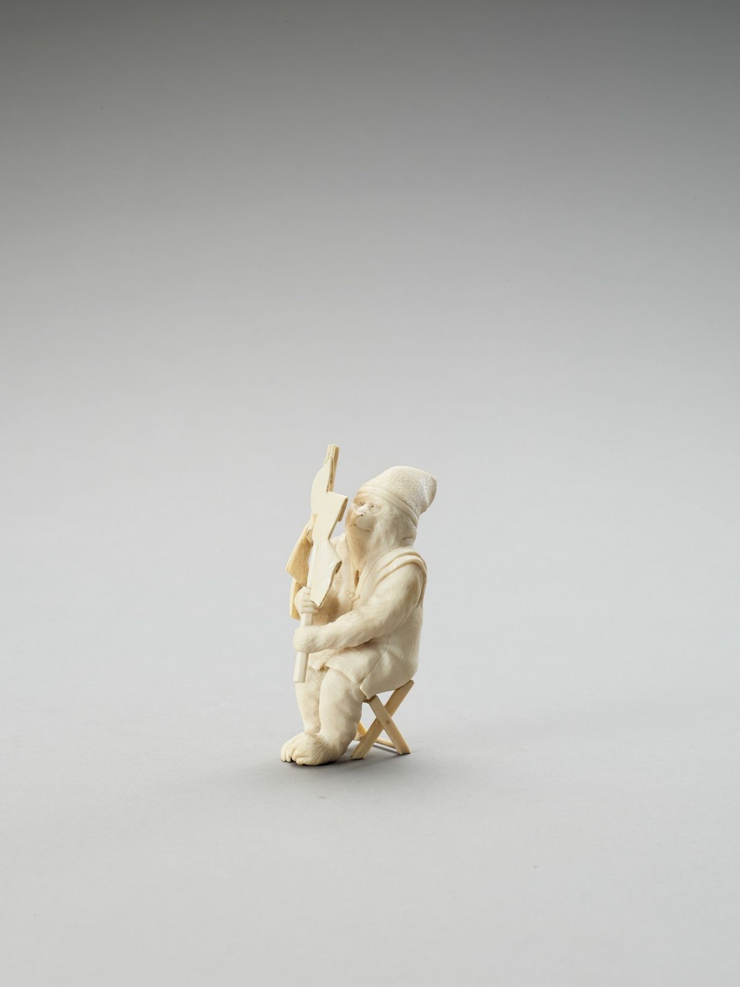 A TOKYO SCHOOL IVORY OKIMONO OF A MONKEY WITH SHIDE