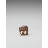 A WOOD NETSUKE OF A CAPARISONED ELEPHANT