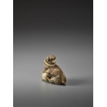 AN IVORY KYOTO SCHOOL NETSUKE OF A DOG WITH A BALL