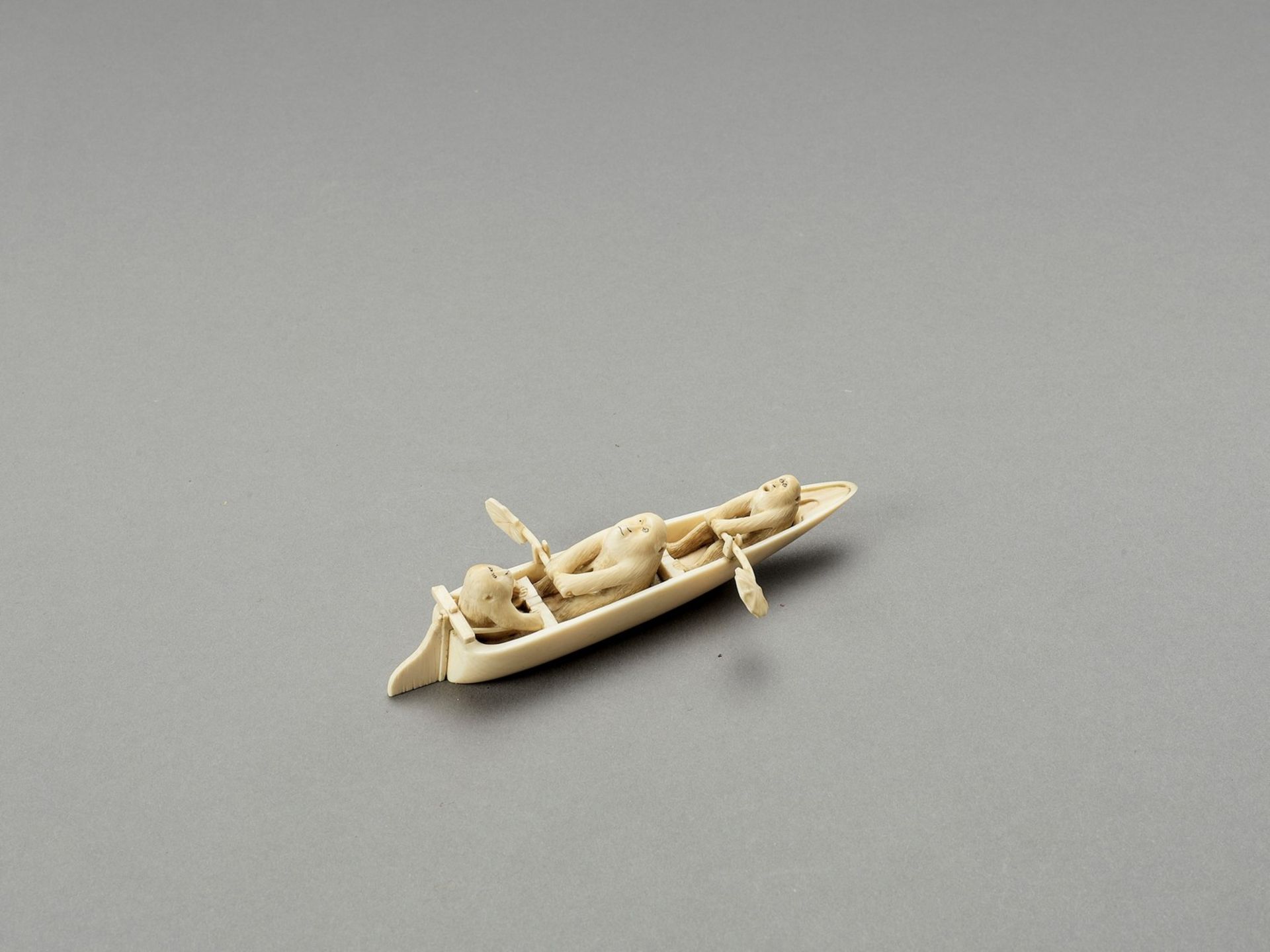 AN AMUSING IVORY OKIMONO OF MONKEYS IN A BOAT