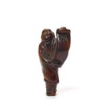 A WOOD NETSUKE OF A MAN WITH SCROLL, C. 1800 TO EARLY 19TH CENTURY