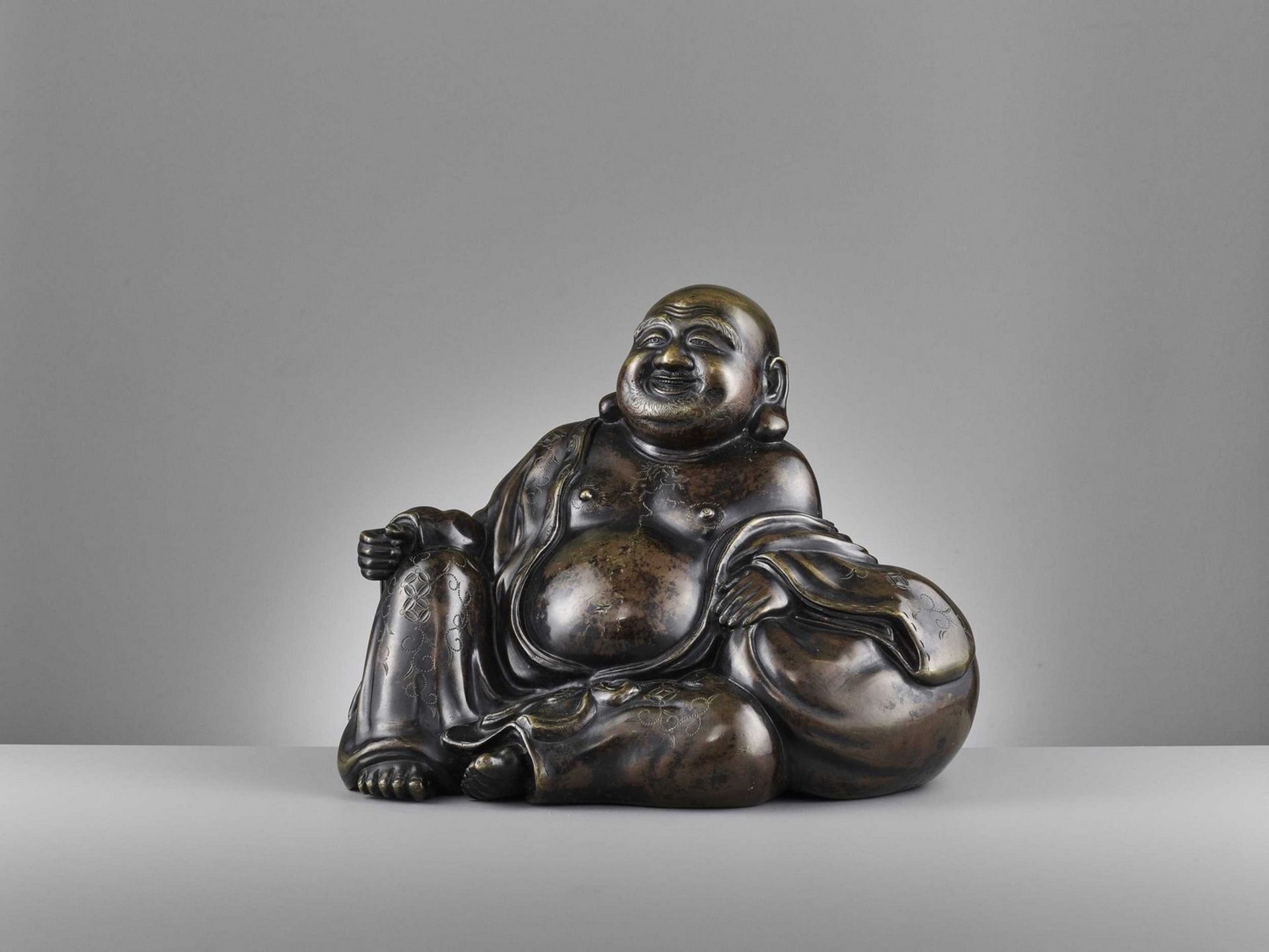 A LARGE AND HEAVILY CAST BRONZE FIGURE OF BUDAI, QING DYNASTY