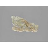 A CELADON JADE ‘DRAGON’ PLAQUE, LATE QING TO REPUBLIC