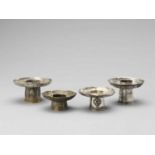 FOUR SINO-TIBETAN SILVER PARCEL-GILT ‘BAJIXIANG’ CANDLE HOLDERS, QING